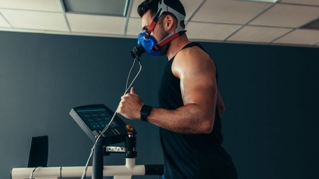 Man on VO2 Max Testing at Cenegenics, Exercise room with VO2Max Test cycling equipment