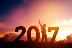 Man cheering in sunrise of 2017 representing a new year