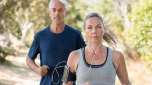 healthy middle-aged man and woman jogging outside and taking control of their health
