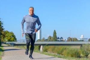 Man exercising for anxiety reduction by running along riverside