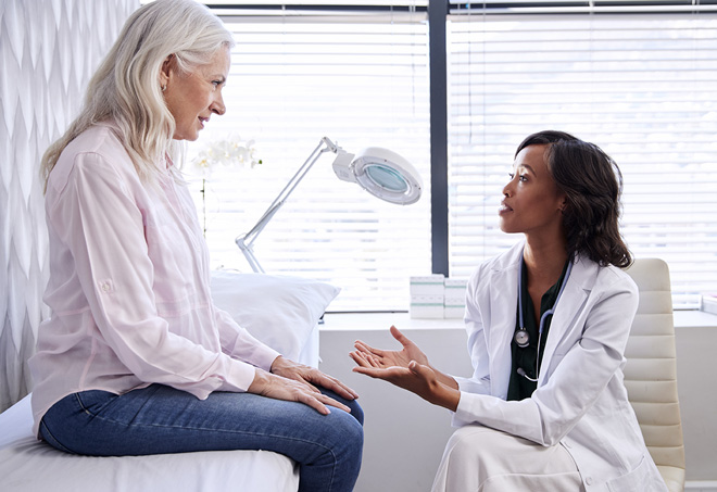 Mature woman speaking with physician in doctor’s office about HRT for women