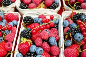 baskets of berries including raspberries, blackberries, blueberries, and strawberries promoting the importance of having daily fruit servings