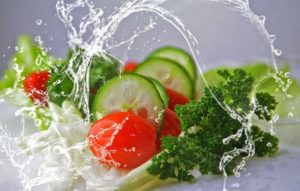 Vegetables being splashed in water including cucumbers, tomatoes, lettuce and parsley promoting heathy eating and increasing vegetable intake