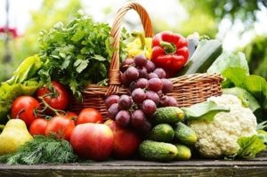 Healthy snack of fruits and vegetables in a basket in garden, all examples of whole food carbohydrates