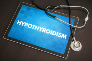 Stethoscope and tablet with blue screen and white letters stating HYPOTHYROIDISM 
