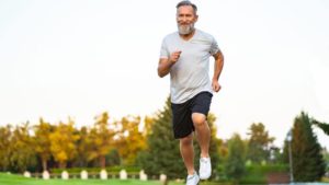 middle aged man with beard running outside to get rid of visceral fat