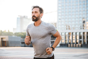 mature man jogging in city, exercising and improving his prostate health