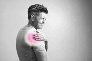 Mature man gripping shoulder in pain experiencing symptoms of low vitamin d