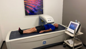Older man laying on DEXA scan machine to measure levels of visceral fat