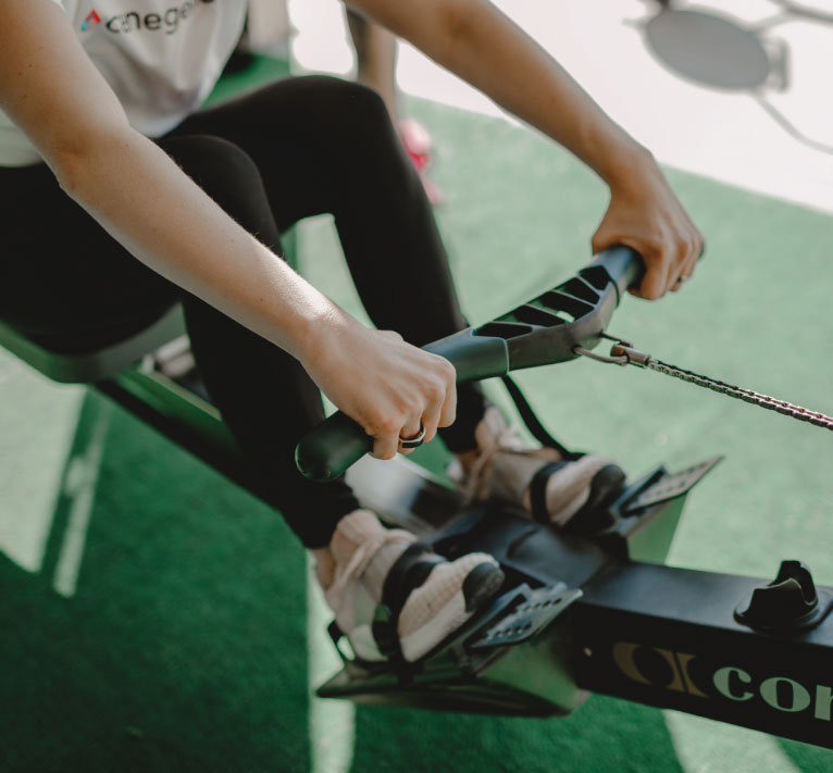 Woman rowing on concept rower in home gym