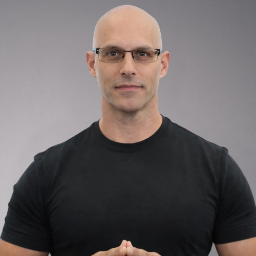 A bald man wearing glasses and a black t-shirt clasps his hands together.